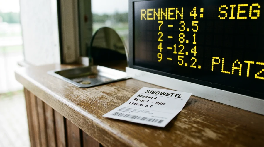 Totalisator-Schalter in Hoppegarten mit Siegwette-Ticket und Quotenanzeige
